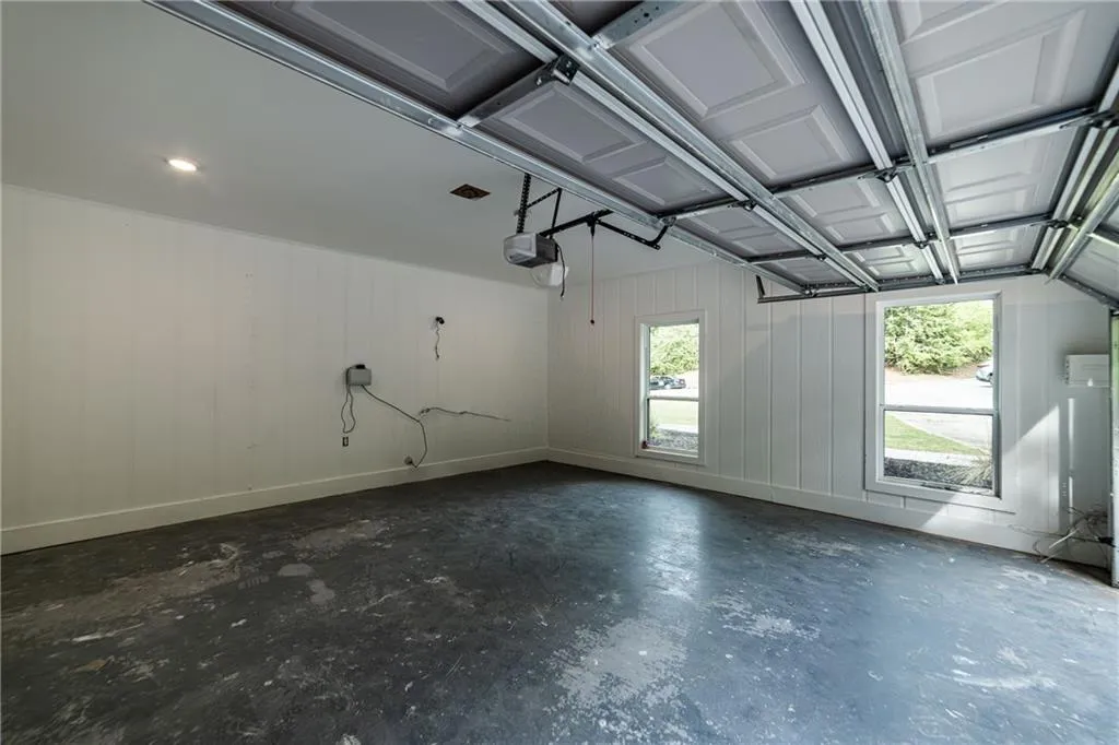 Garage featuring wooden walls and a garage door opener