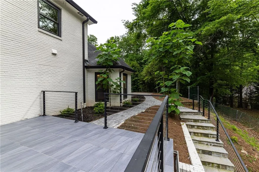 View of patio featuring stairs and view of wooded area