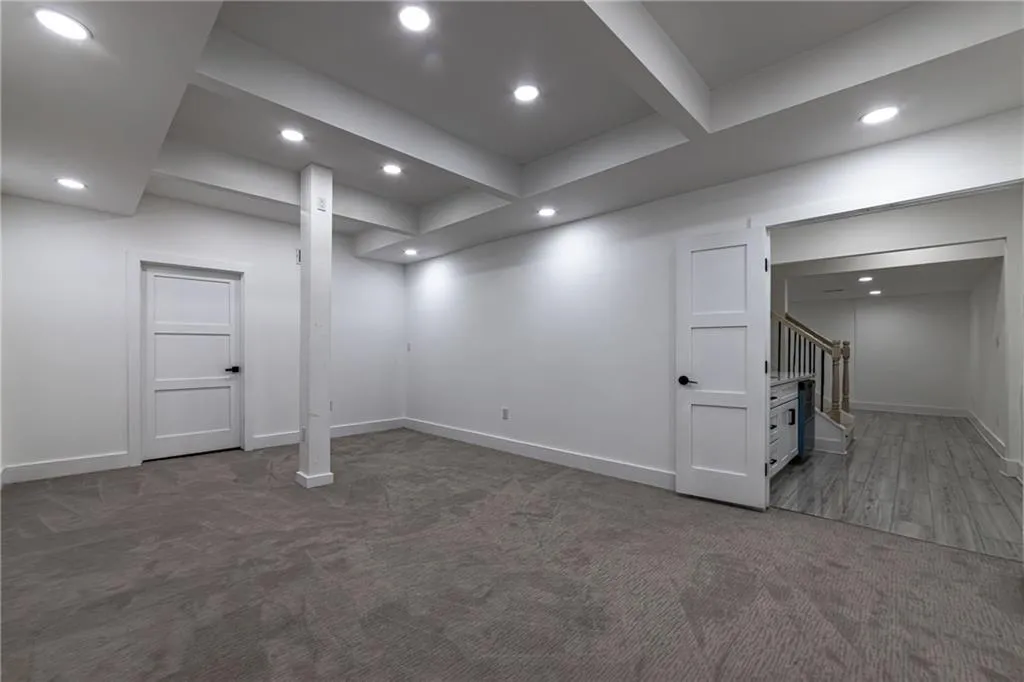 Finished basement featuring carpet, recessed lighting, and stairway
