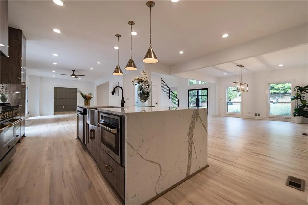Kitchen featuring open floor plan, light wood finished floors, ceiling fan, dark brown cabinetry, and recessed lighting