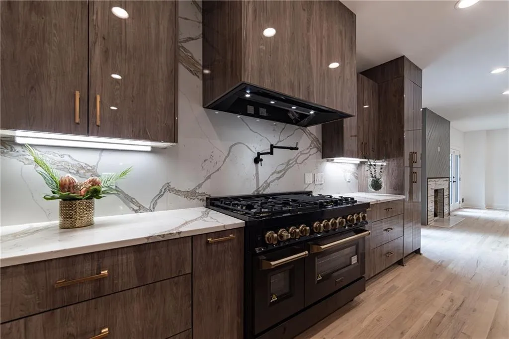 Kitchen with range with two ovens, backsplash, modern cabinets, ventilation hood, and recessed lighting