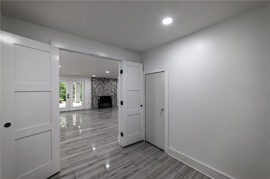 Corridor featuring french doors, wood finish floors, and recessed lighting