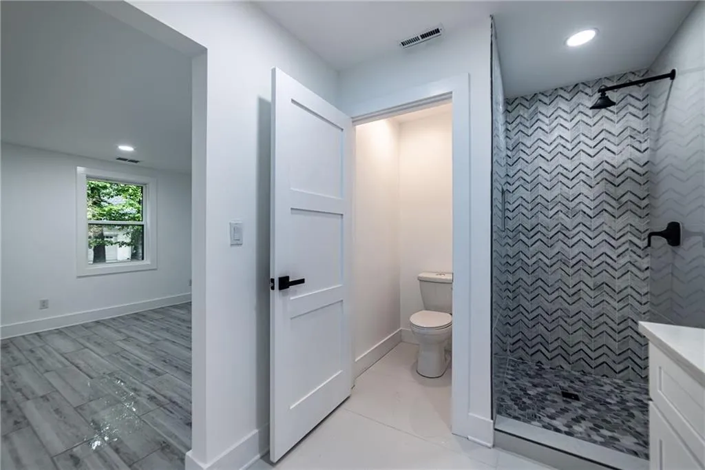 Full bathroom featuring recessed lighting, a tile shower, and vanity