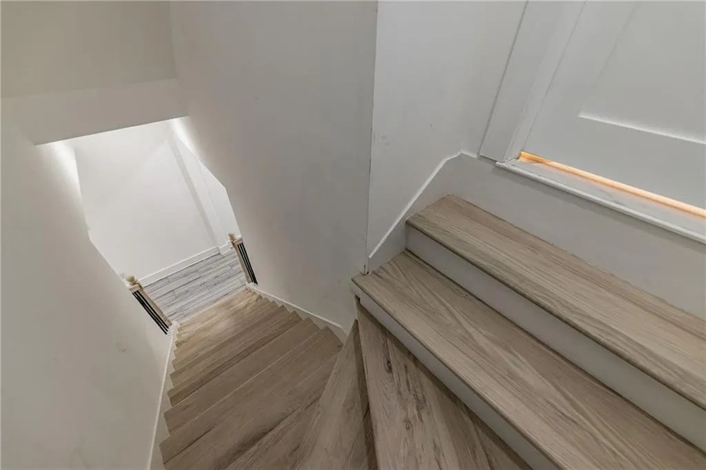 Stairway with wood finished floors and baseboards