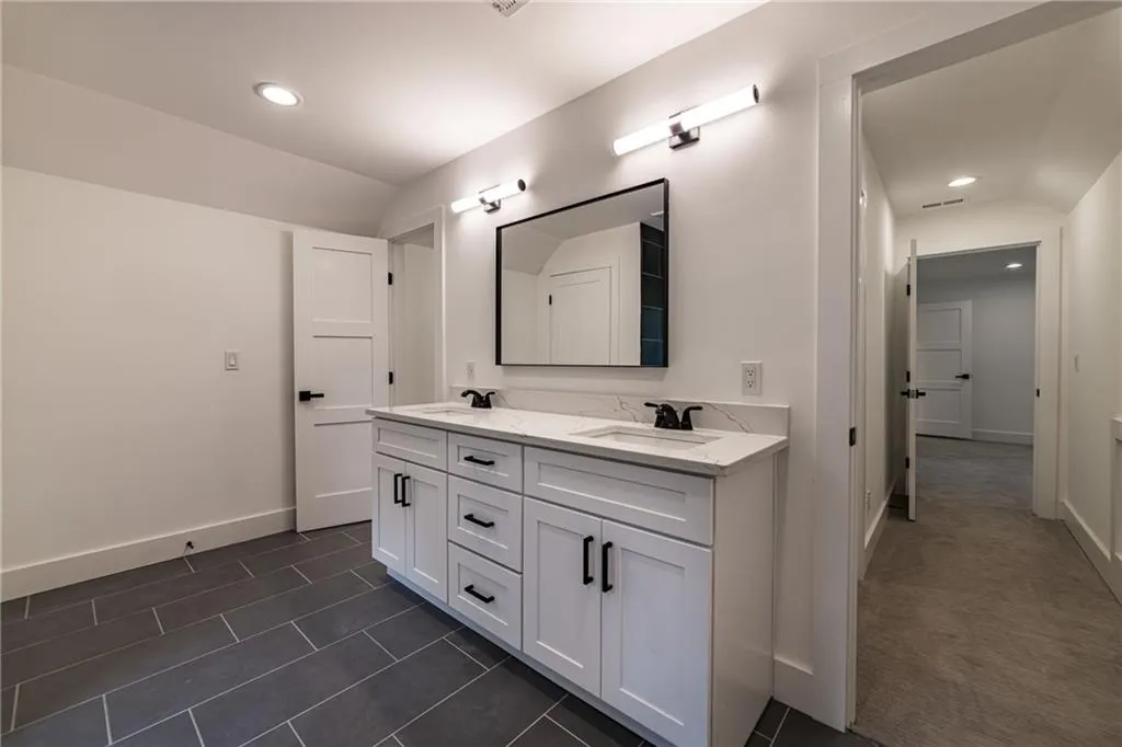 Bathroom featuring double vanity, recessed lighting, and tile patterned flooring