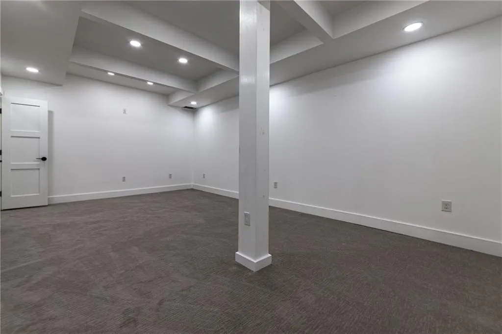 Finished below grade area featuring dark carpet and recessed lighting