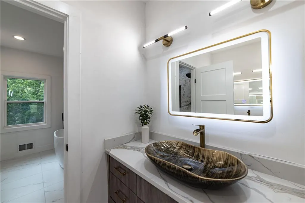 Bathroom with vanity, marble finish flooring, and recessed lighting