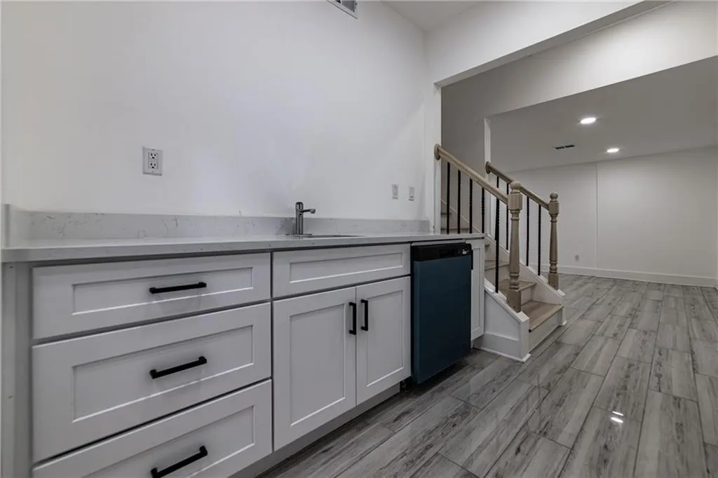 Bar featuring stairway, dishwashing machine, wood tiled floors, and recessed lighting