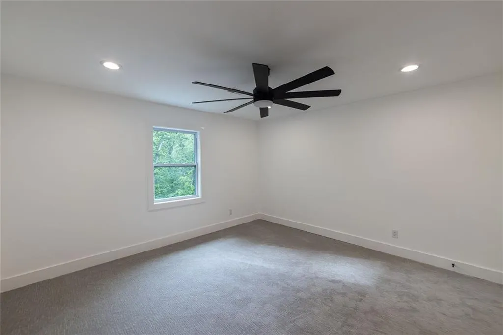 Carpeted empty room with baseboards and recessed lighting