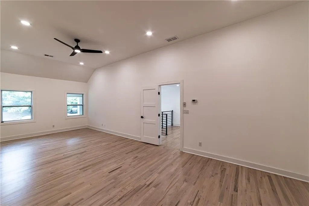 Unfurnished room featuring light wood-type flooring, vaulted ceiling, ceiling fan, and recessed lighting