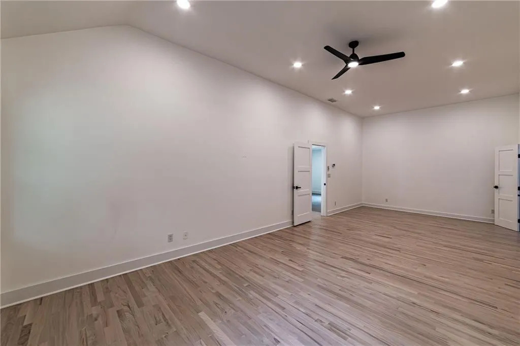 Spare room featuring light wood-style flooring, ceiling fan, and recessed lighting