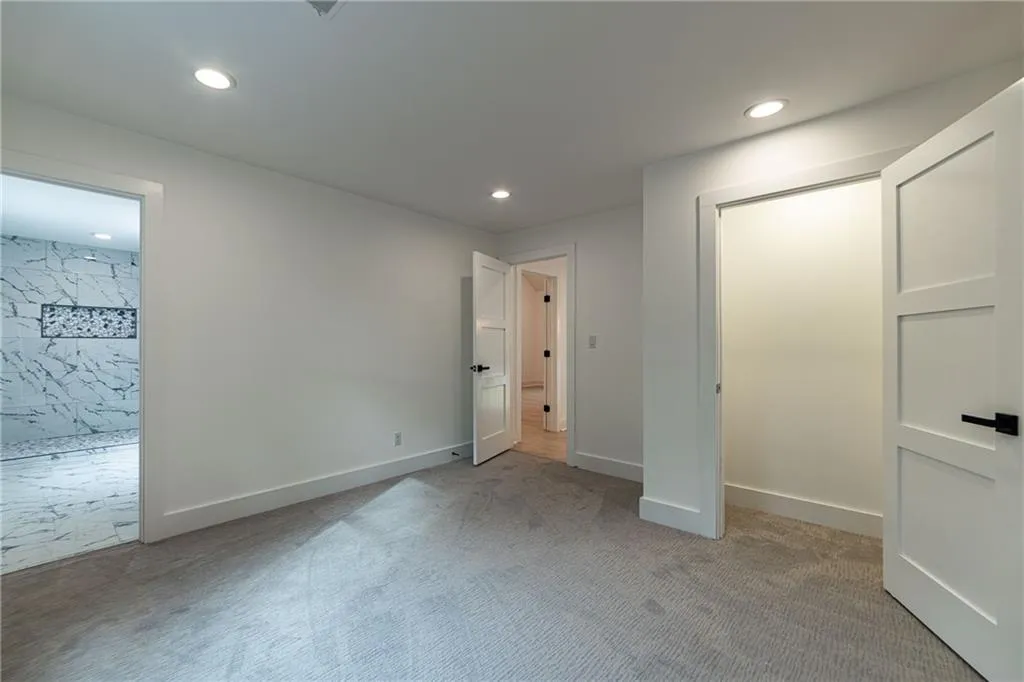 Unfurnished bedroom with light colored carpet and recessed lighting