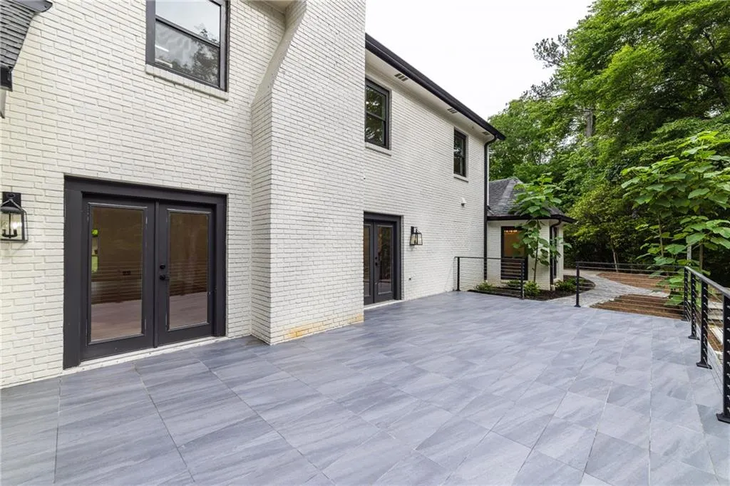 Rear view of house with a patio, brick siding, and french doors