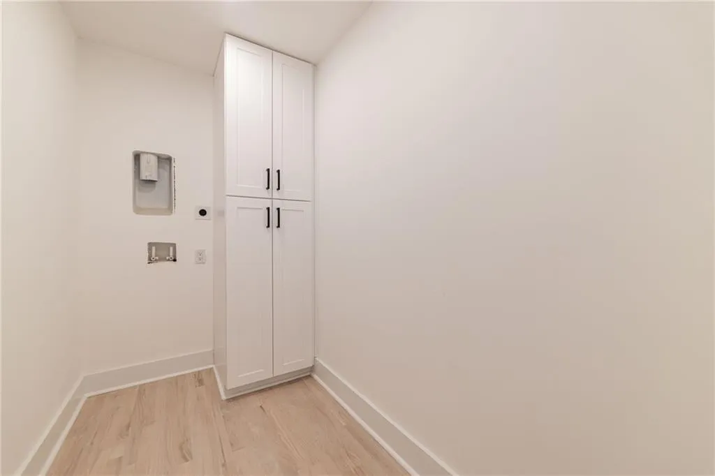 Laundry room with cabinet space, hookup for an electric dryer, light wood-style flooring, and hookup for a washing machine