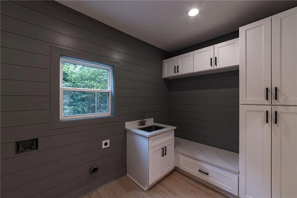 Mudroom featuring wood walls, light wood-style floors, and recessed lighting