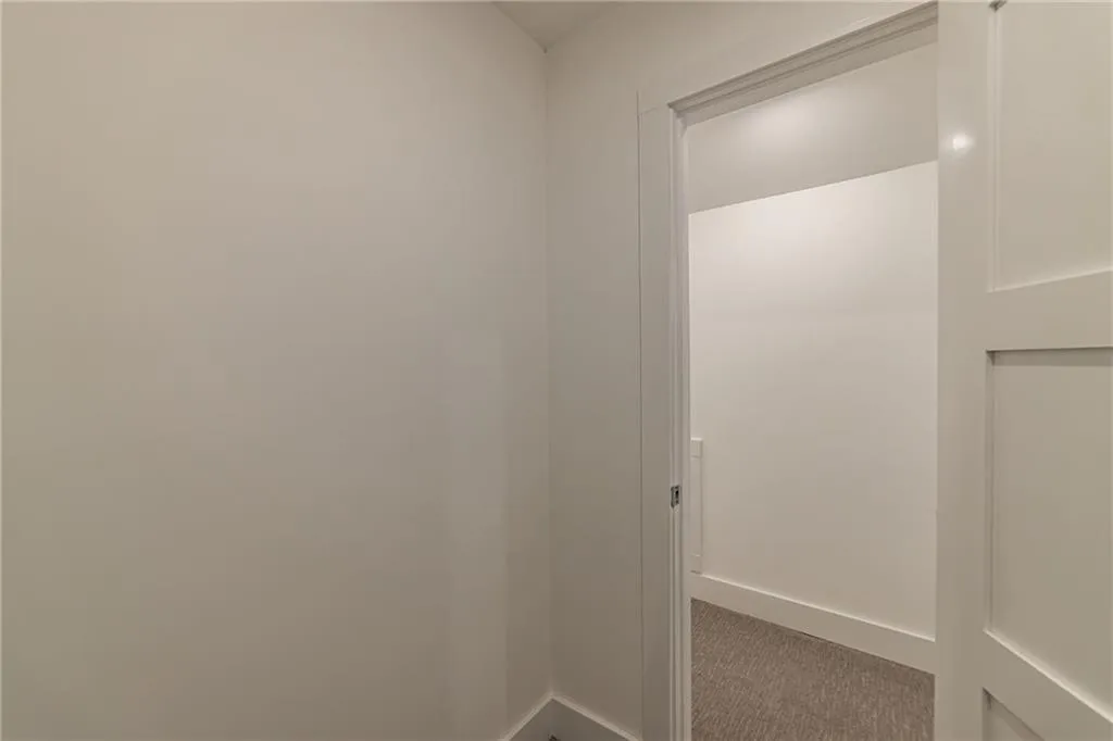 Hallway with carpet and baseboards