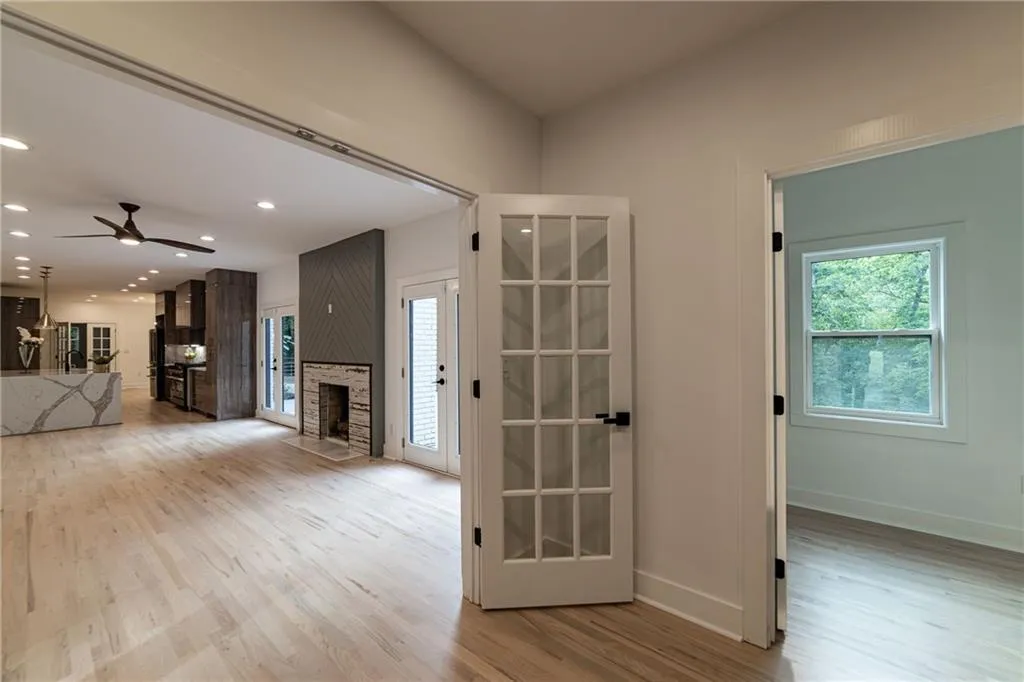 Unfurnished living room with light wood finished floors, a large fireplace, ceiling fan, and recessed lighting