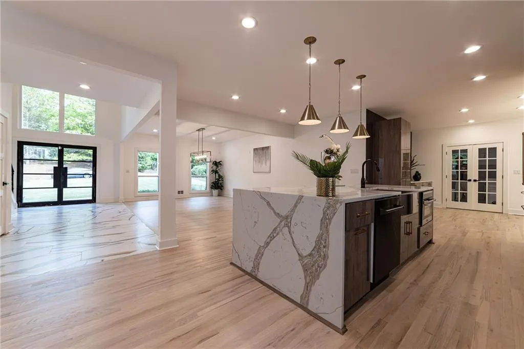Kitchen with french doors, open floor plan, an island with sink, recessed lighting, and light wood-type flooring
