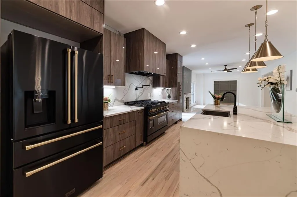 Kitchen with black appliances, modern cabinets, tasteful backsplash, a ceiling fan, and pendant lighting