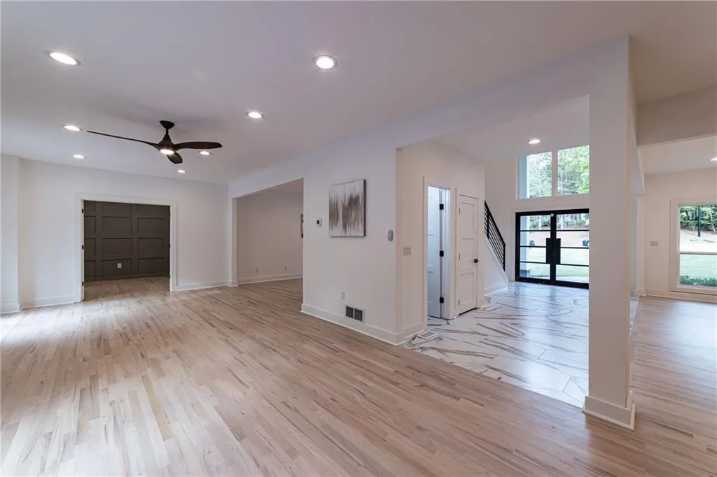 Unfurnished room featuring recessed lighting, light wood-style flooring, a ceiling fan, stairway, and french doors