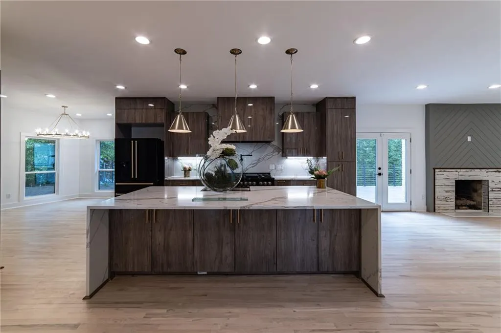 Kitchen featuring tasteful backsplash, modern cabinets, light wood-type flooring, dark brown cabinetry, and recessed lighting