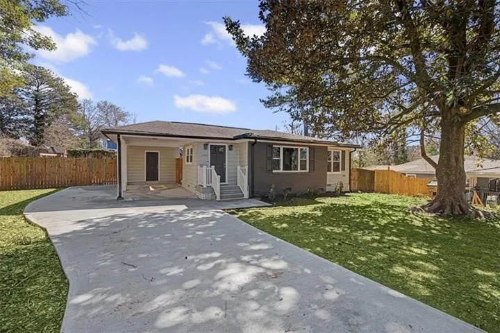 Newly constructed residence featuring a light-colored facade with dark gray accents