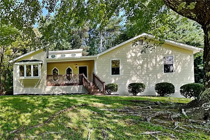 Exterior with siding finish, covered front porch, wooden deck, and bay window