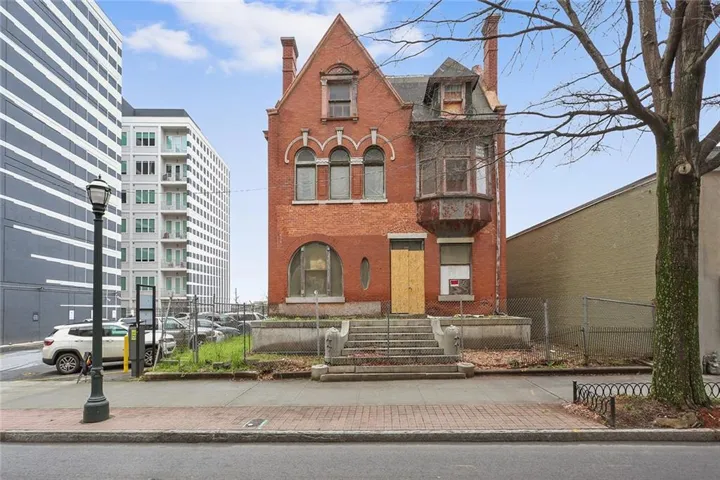 View of front facade featuring a chimney and brick siding