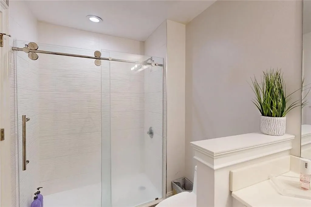 Bathroom featuring a shower stall, vanity, and recessed lighting