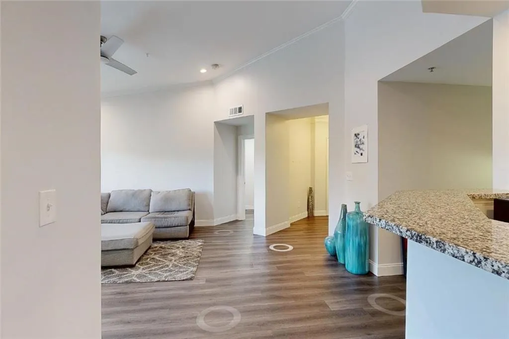 Living area with wood finished floors, ornamental molding, recessed lighting, and ceiling fan
