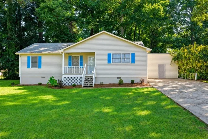Ranch-style exterior with vinyl siding and blue window shutters