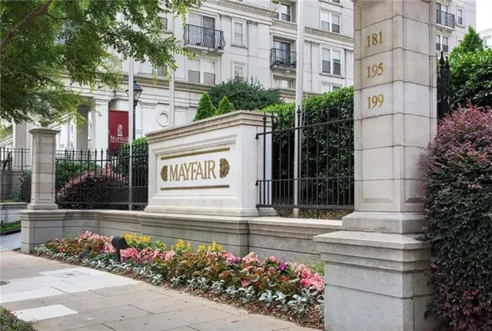 Stone entry monument featuring "MAYFAIR" inscription and gold-toned building numbers