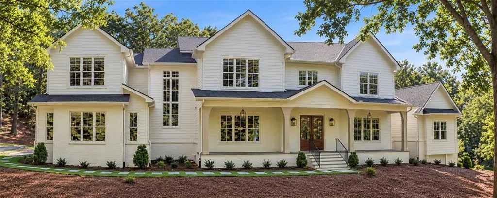 White painted brick and siding exterior with multiple gables