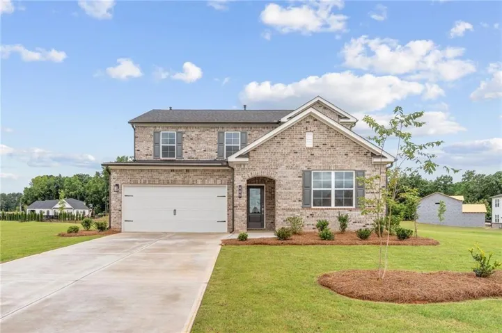 Traditional style home featuring a brick facade, dark gray window shutters, and a two-car garage