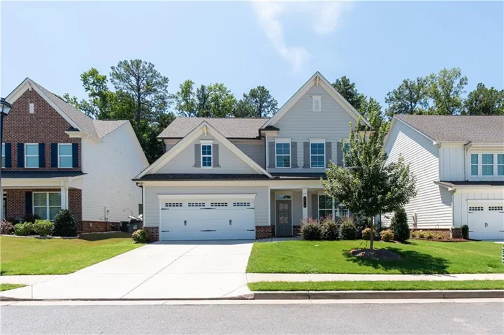 Contemporary two-story home featuring light gray siding and stone accents