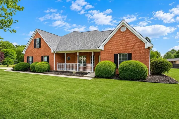 Brick exterior with gabled roof lines and a covered front porch featuring white railings