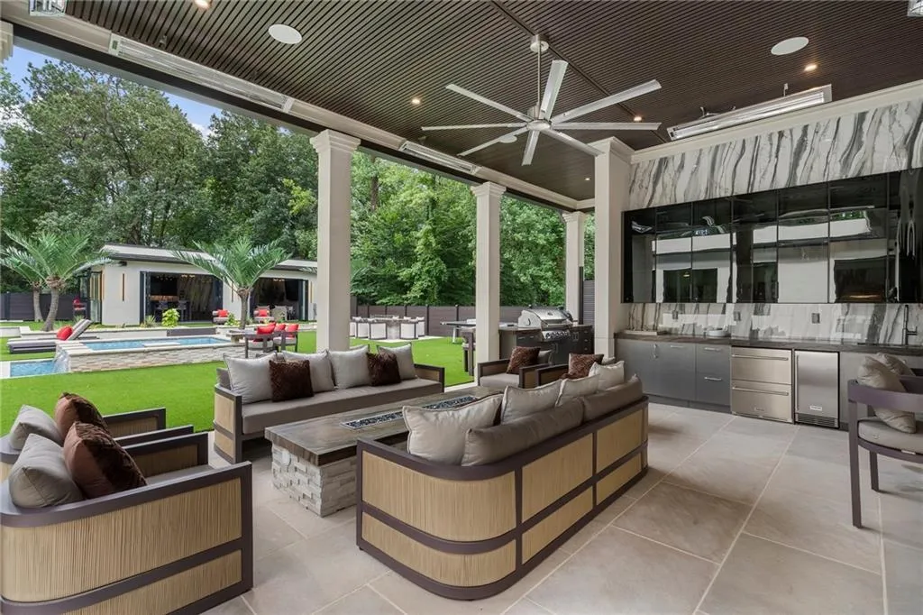 Covered patio with pool bath, shower, outdoor kitchen, linear fire table and patio heaters
