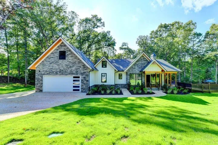Stone and board and batten exterior with an attached garage