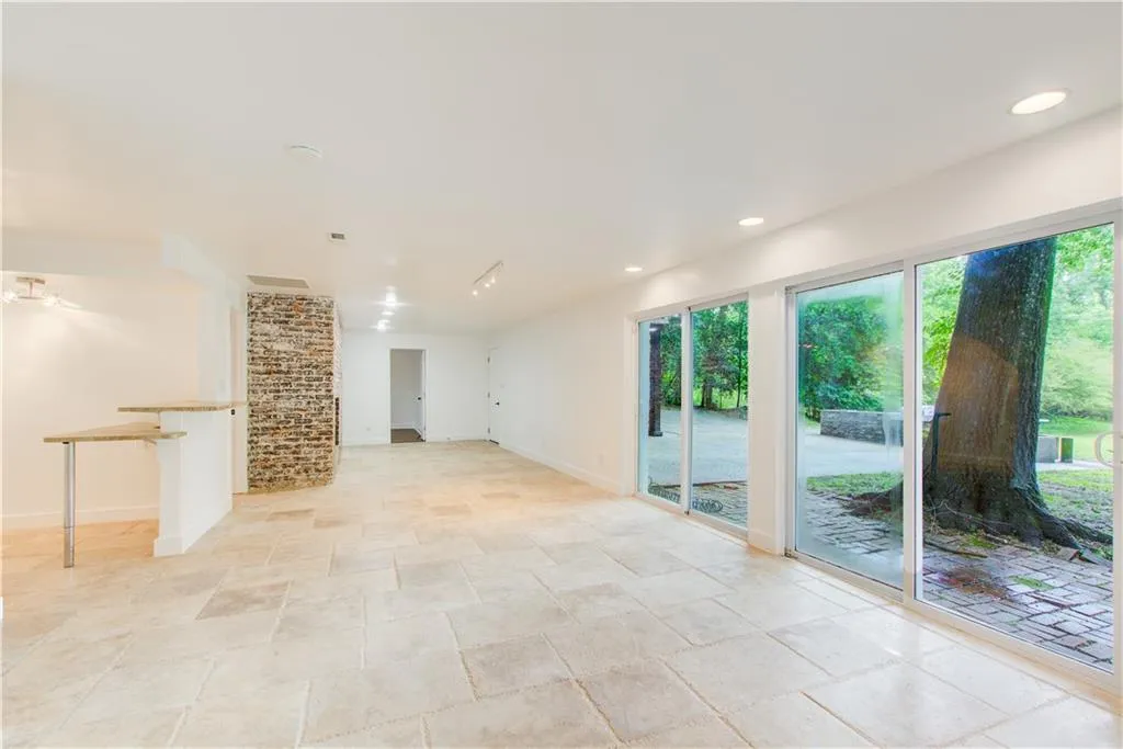 Unfurnished living room featuring stone tile flooring, baseboards, and recessed lighting