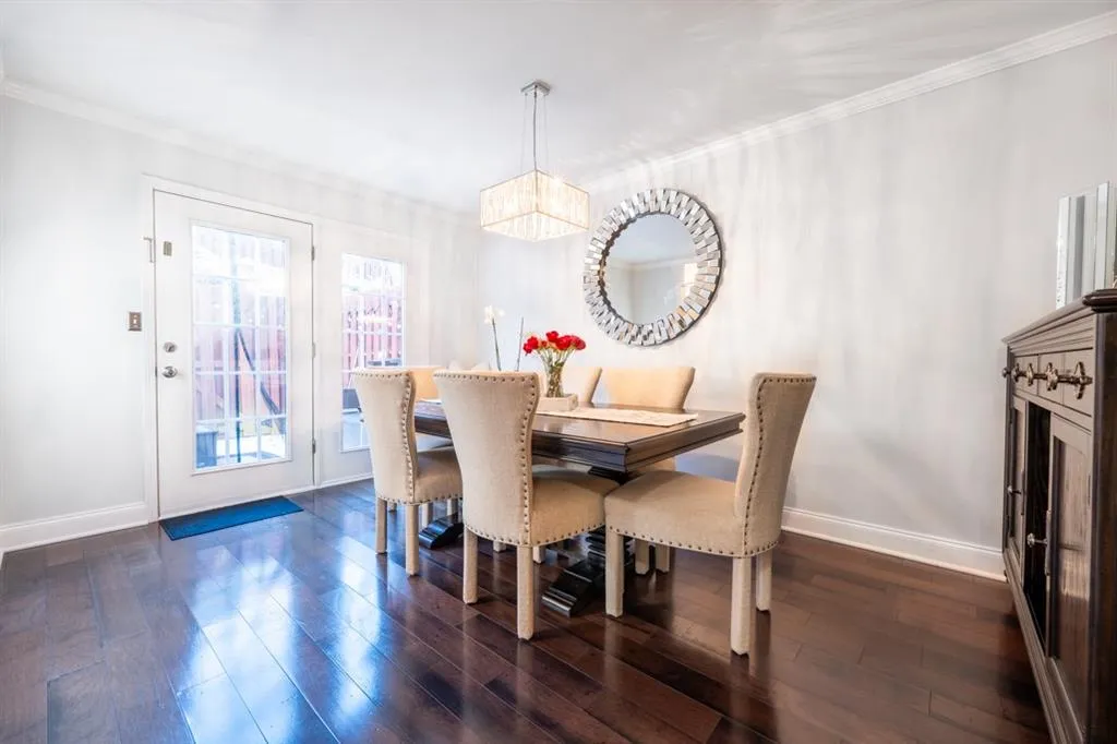 Dining room featuring ornamental molding, a chandelier, dark wood finished floors, and baseboards