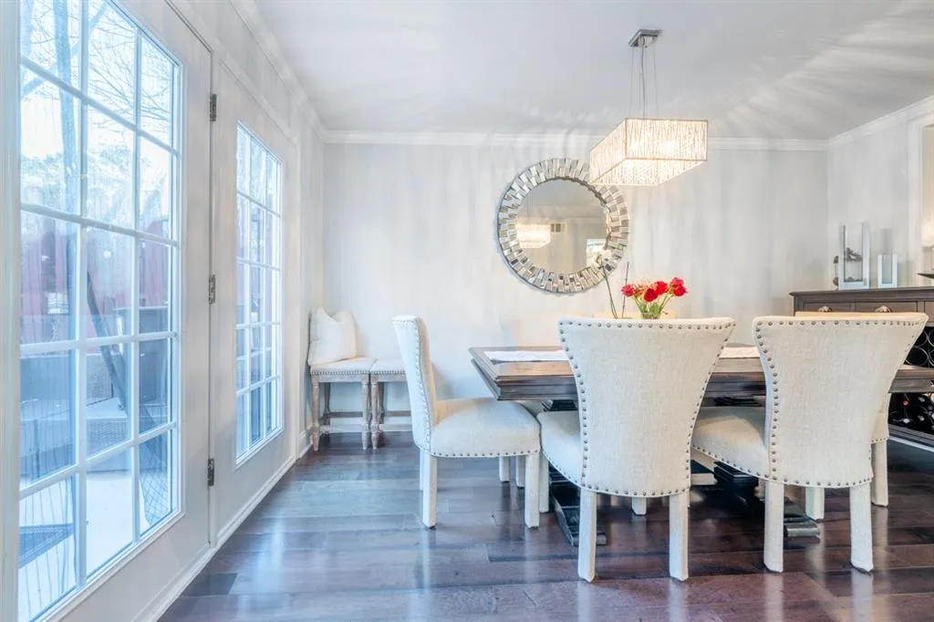 Dining area featuring dark wood-style floors, ornamental molding, and a chandelier