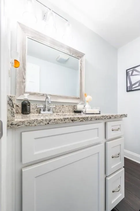 Half Bathroom featuring wood finished floors, vanity, and baseboards