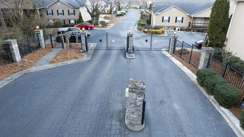 View of street with a gate, curbs, and a gated entry