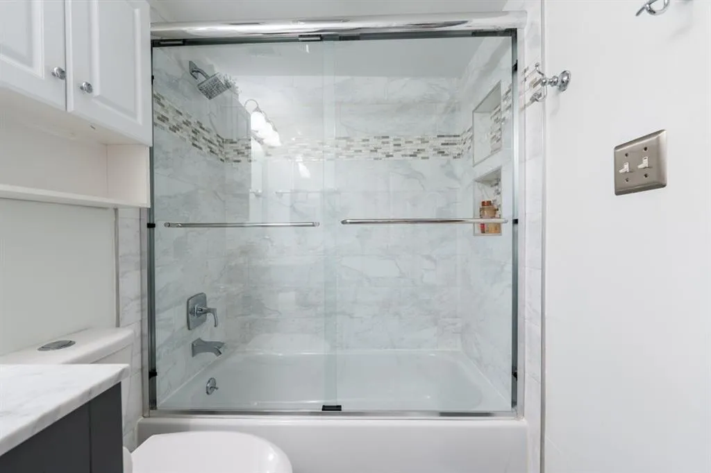 Guest Bathroom with toilet, combined bath / shower with glass door, and vanity