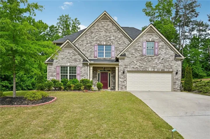 Brick exterior with gabled roofline, front-facing two-car garage, and a concrete driveway