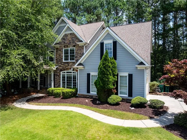 Two-story home featuring a combination of stone and siding exterior
