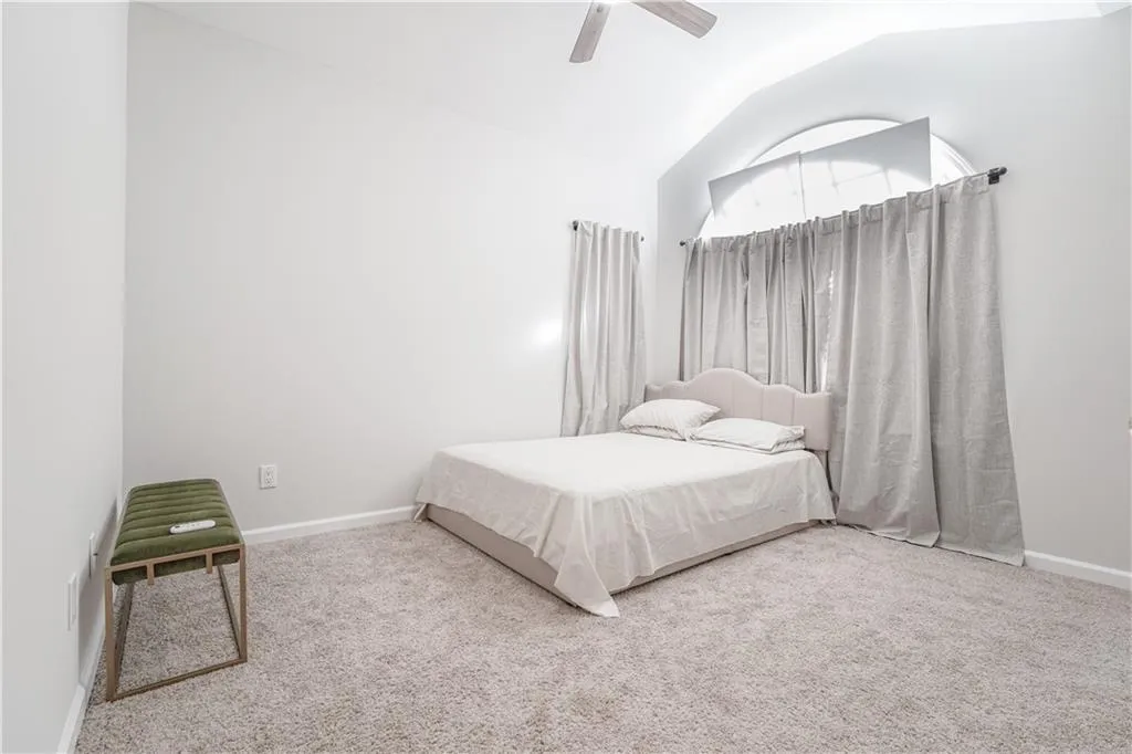 Bedroom featuring lofted ceiling, carpet, and ceiling fan