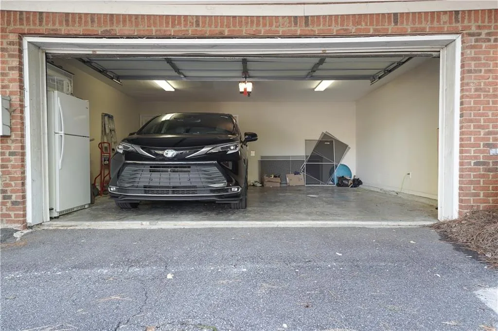 Garage with freestanding refrigerator and asphalt driveway
