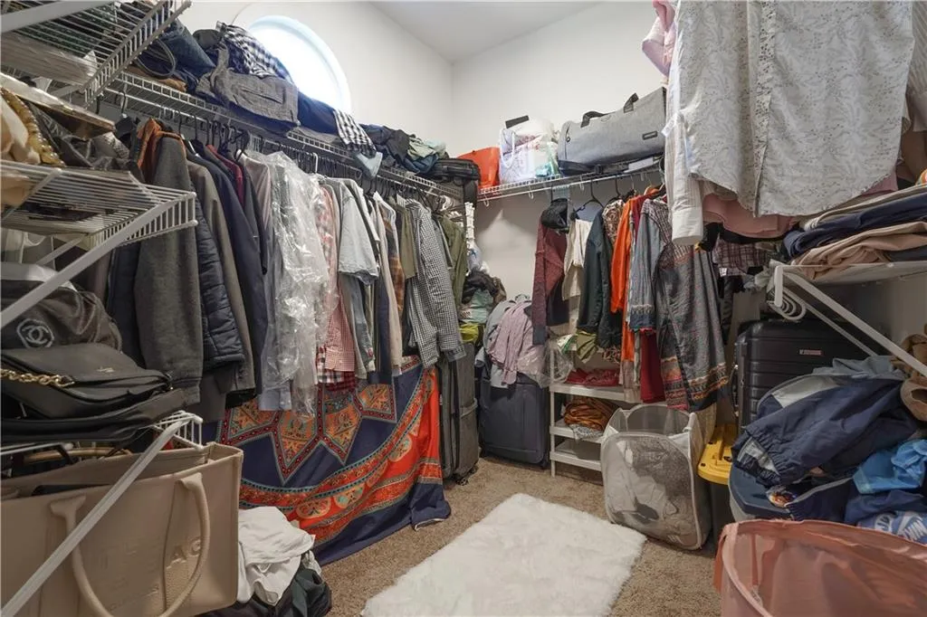 Walk in closet with light colored carpet