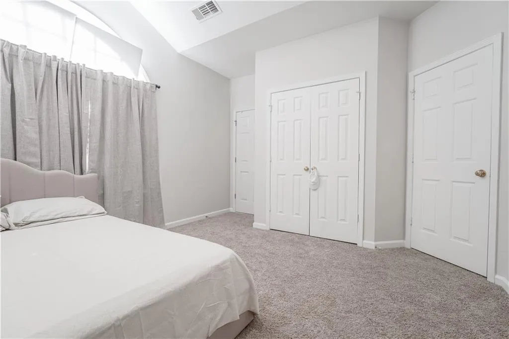Bedroom featuring light colored carpet and a closet